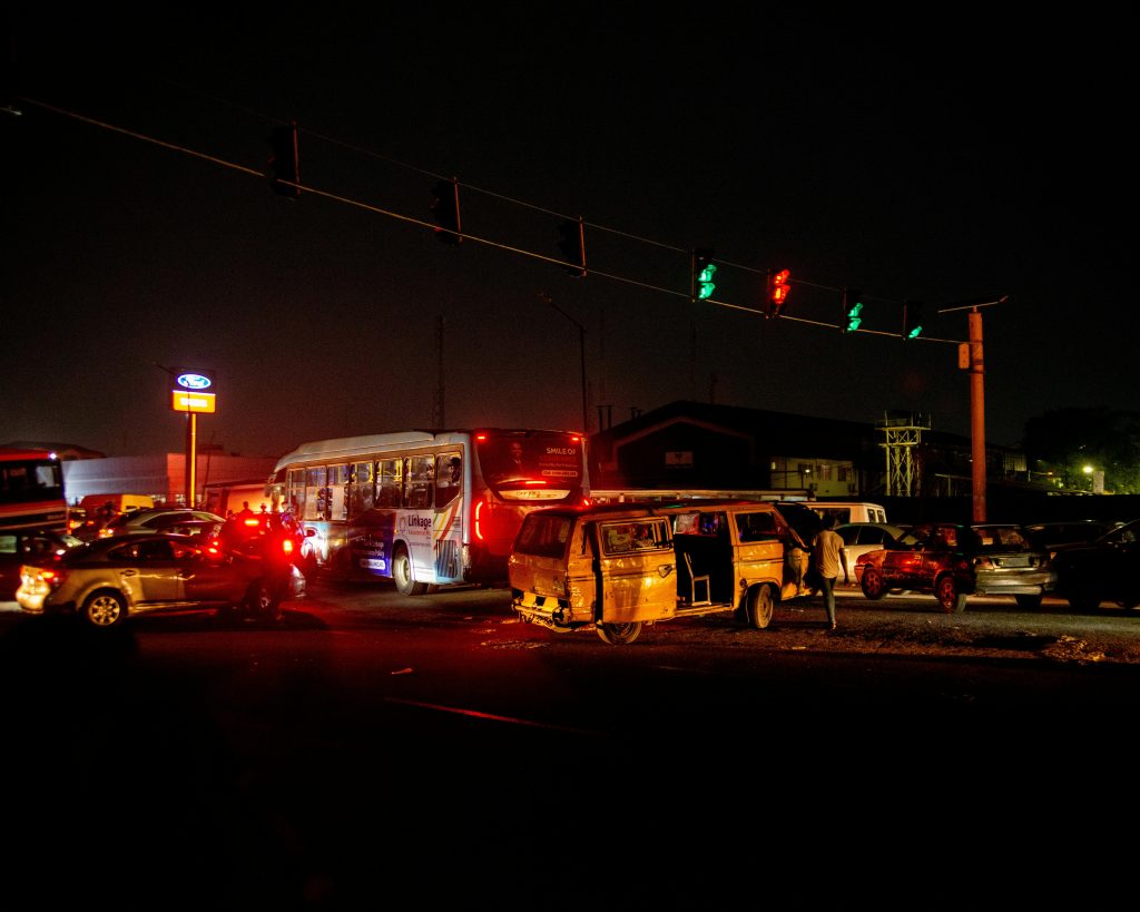 a traffic light at night with cars and buses