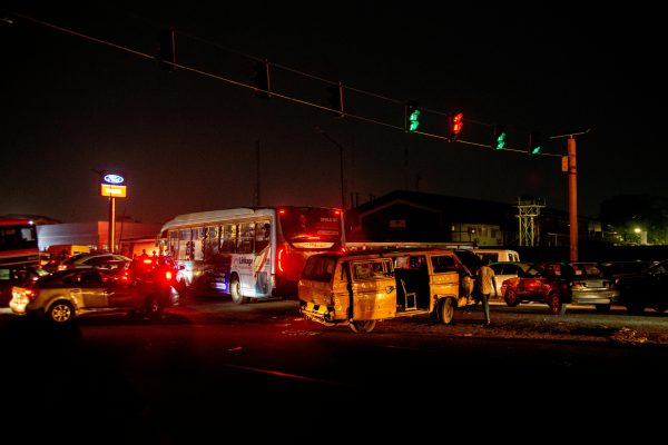 a traffic light at night with cars and buses